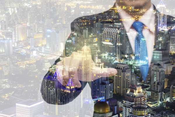 Double exposure of businessman with cityspace vision